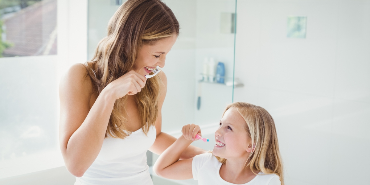 Mom and Daughter Brushing Teeth in Bathroom